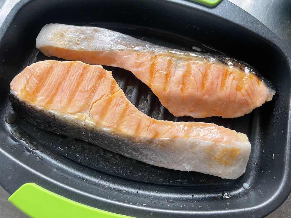 レンジで焼ケールで調理する途中のシャケの切り身の写真
