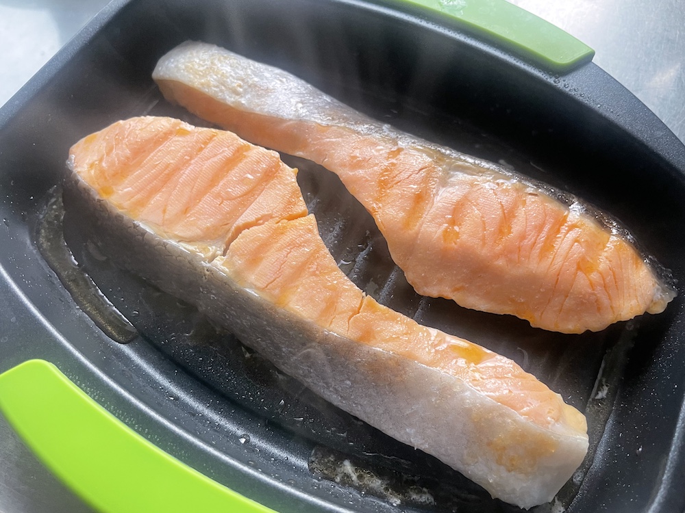 レンジで焼ケールで調理する途中のシャケの切り身の写真