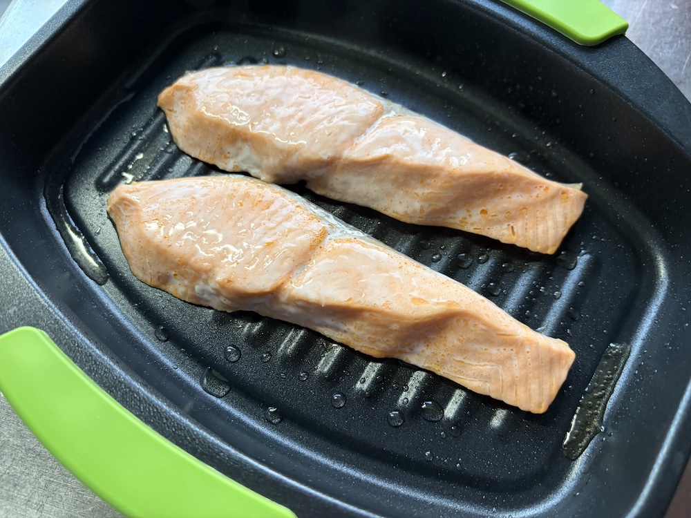 レンジで焼ケールで調理する途中のシャケの切り身の写真